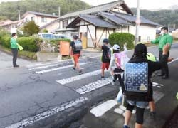 児童の道路横断をサポートするJA職員