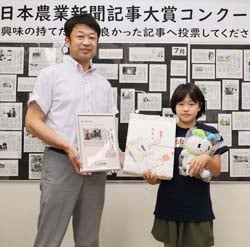 大賞の堀内さんに取材対応への感謝を伝え、記念品を手渡した受賞式