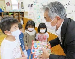 洗馬っ子の成長を願いながら記念品を渡す北沢泉組合長