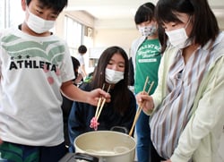 湯せんした毛糸の着色状態を観察する児童