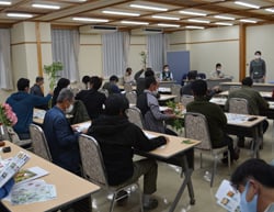 花を手に取りながら種苗会社が説明する品種説明会