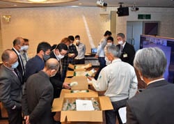 キノコを手に取り意見交換する生産者