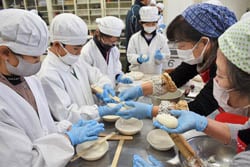 JA女性部メンバーに教わり五平餅を作る児童ら