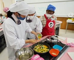 女性部に指導を受け、郷土料理を作る高校生