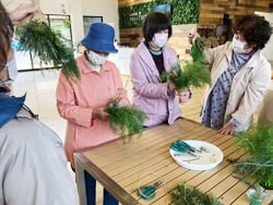 自ら収穫したハーブを使って「スワッグ」づくりを行う支部員