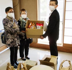 山宮センター長（左）に食品などを手渡す若林支会長（左から1番目）と久保支会長（左から2番目）