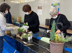 山口講師（左）の指導で寄せ植えに挑戦する参加者