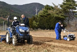 実演会で農業機械を操作する参加者ら