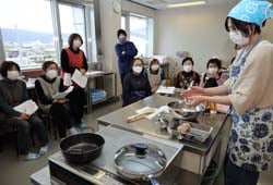 矢木さん（右）から、寒天が入ったハンバーグのつくり方を学ぶ部員