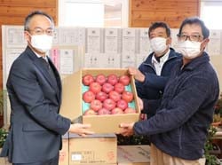 中川校長（左）にリンゴを手渡す上條部会長（中）と村山支部長（右）