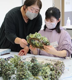 講師のアドバイスを受けながらリースを作る網野さん（右）