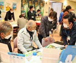 担当者の説明を聞く来場者