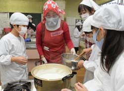 部員の指導を受け呉汁を暖めている児童ら