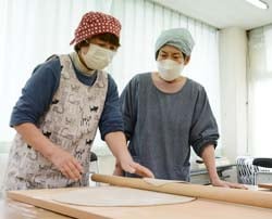 教えあいながらそば打ちを行う部員