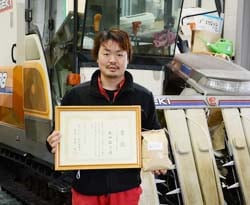 賞状と自慢の米「風さやか」を手にする丸山さん