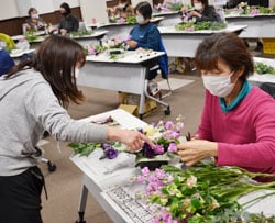 植え方をアドバイスする城倉さんと真剣に取り組む参加者