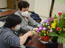 中村講師（左）に教わりながらアレンジメントを行う参加者（右）