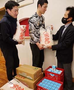 寄贈された農産物を受け取る部員