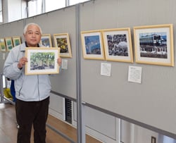 支所ロビーに並ぶ風景写真と丸山さん