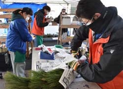 松飾りを包む職員