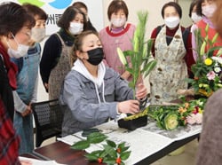 矢﨑講師（中央）に花の生け方などを教わる参加者