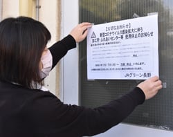 加工所に利用停止のお知らせを貼る職員