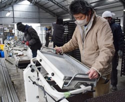 専用の播種機で種をまく組合員