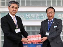 市川事務長（左）に牛乳を渡す高栁副組合長