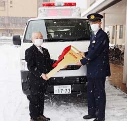 交通事故処理車両のゴールデンキーの受け渡しを行った小松組合長（左）と篠原署長