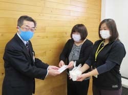 小池常務理事（左）に寄付金とエコ石鹸を手渡す塩原はるみ部長（中央）と事務局の太田さん（右）