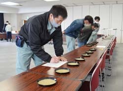 真剣な表情で玄米を見極める検査員