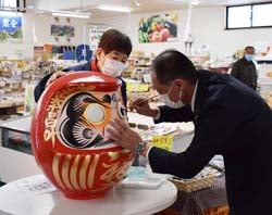 だるまの目入れを行う白鳥常務
