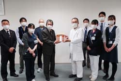 朔院長（中央右）に感謝とともにハムを手渡す寺沢組合長（中央左）