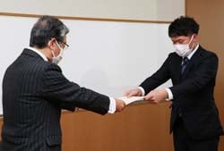 田中組合長から支援金を受け取る本木さん（右）