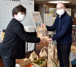 女性部各支部より集まった食料品を寄贈する荻久保さん（左）