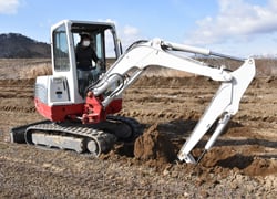 重機で芋を掘る穴を掘りすすめる生産者