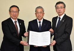 譲渡契約書を手にする眞島組合長（中）と長野厚生連社浦理事長（左）、長野中央会武重専務理事（右）