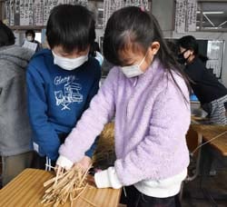 わらつと作りを体験する児童