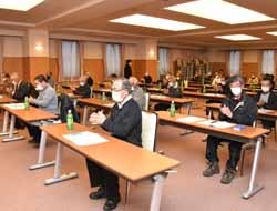 拍手で議案を承認する会場