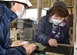 種の入っていない穴を確認し、丁寧に種をまく会員ら