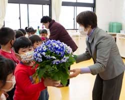 園児たちに花を手渡す森田支部長