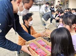 感謝を込めて地元産のいちごを手渡す班員