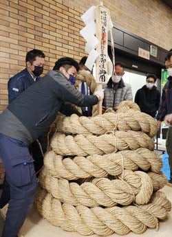 綱飾りを飾る神戸神社と四賀八和会のメンバー