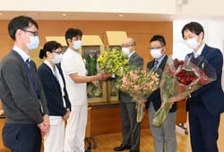 病院職員ら（左側）へアルストロメリアを贈る佐藤委員長ら