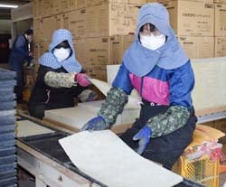 専用マットを敷く従業員