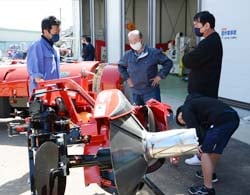 展示された農機具の前で商談する来場者