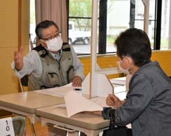 仕事内容を説明する（左）と話を聞く求職者（右）