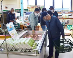 職員の呼び込みに足を止め、肉を選ぶ来店者
