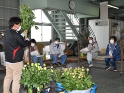 見本を示し出荷規格を説明する営農技術員（左）