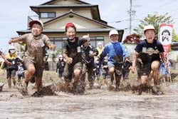 全身で代かきを楽しむ児童（長地小学校）